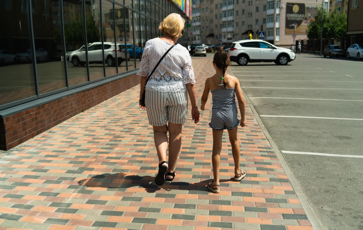 Kind am Gehweg mit Oma