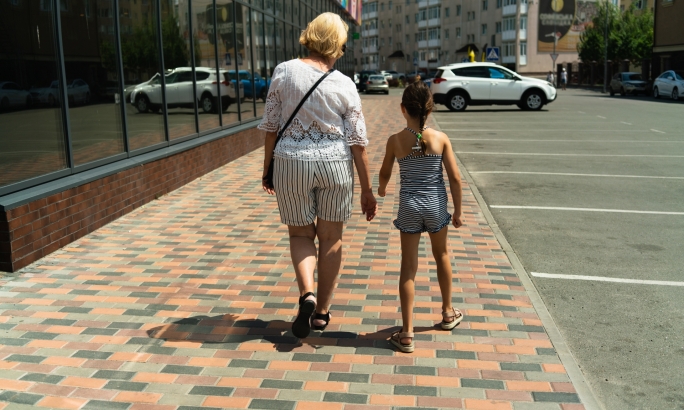 Kind am Gehweg mit Oma