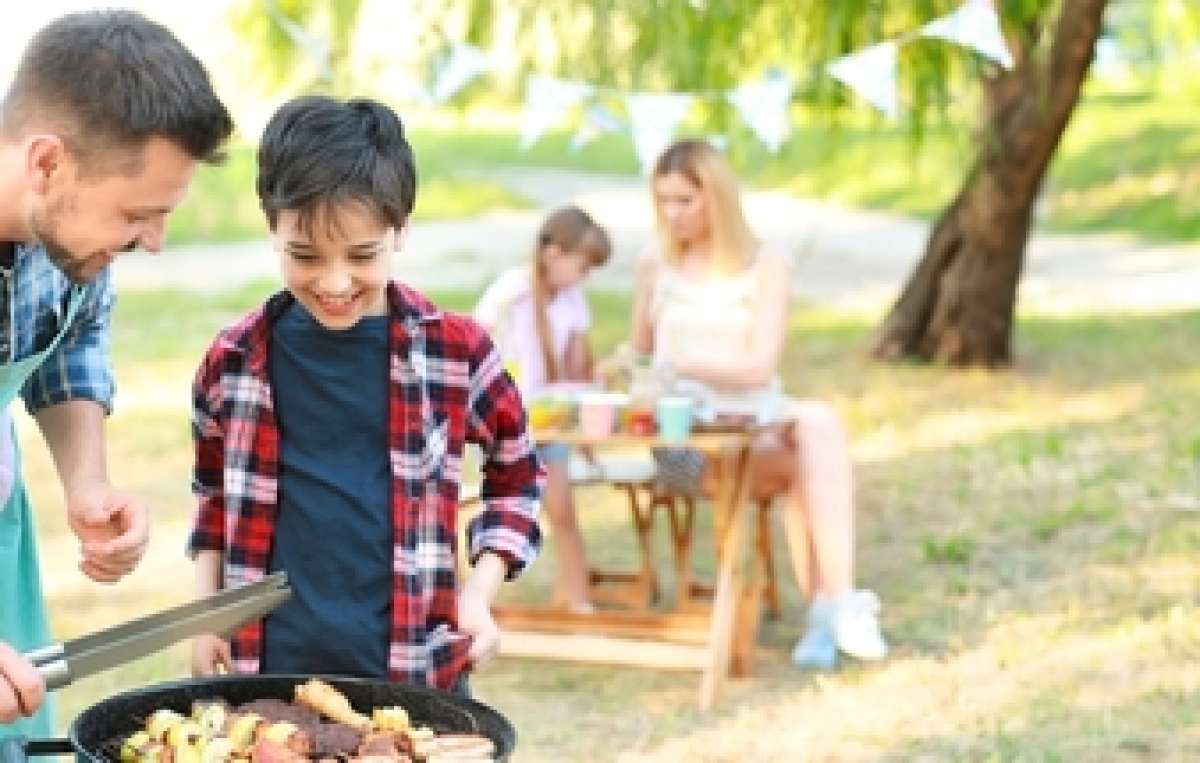 Kind und Mann grillen zusammen