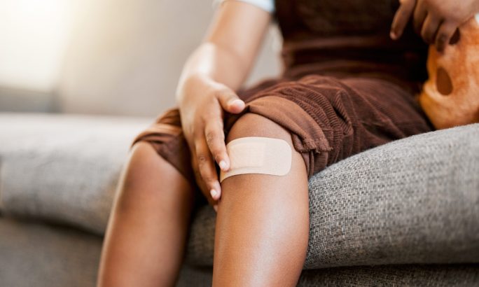 Kind mit Pflaster am Knie