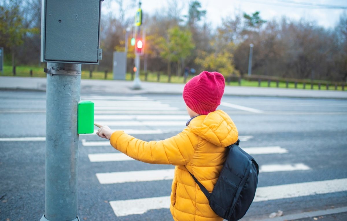Kind vor Zebrastreifen vor roter Ampel