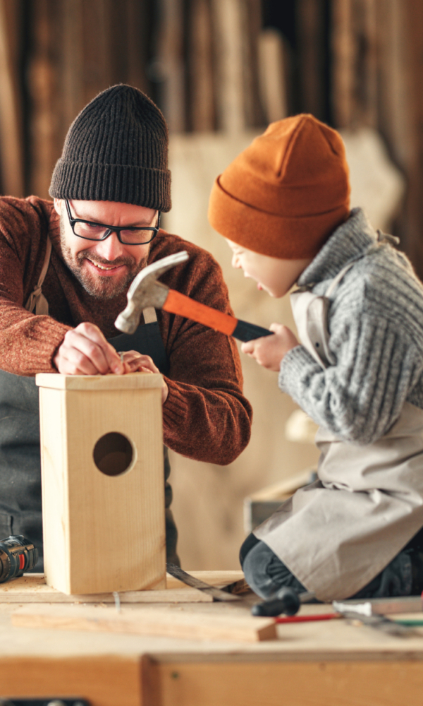 Kind baut mit Vater ein Vogelhaus