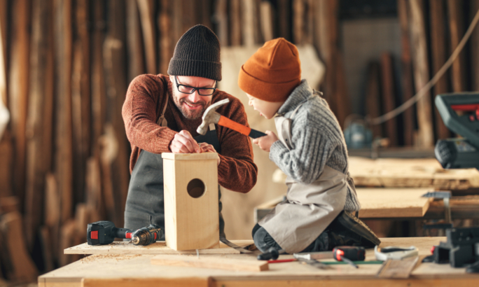 Kind baut mit Vater ein Vogelhaus