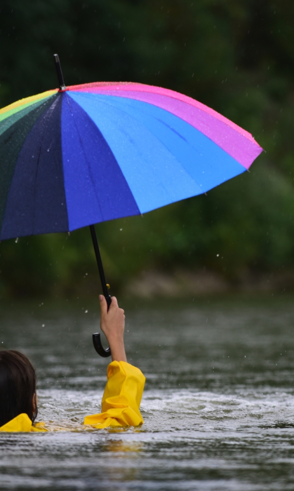 Frau mit Regenschirm im Wasser
