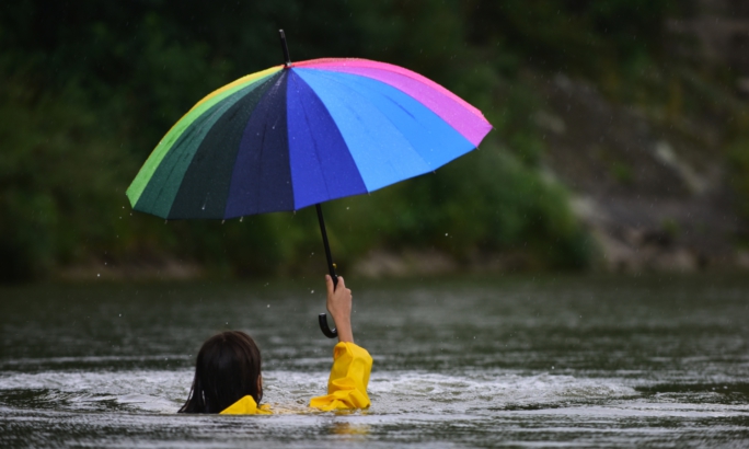Frau mit Regenschirm im Wasser