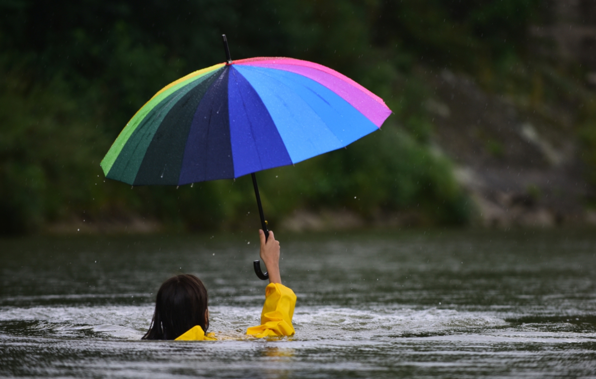 Frau mit Regenschirm im Wasser