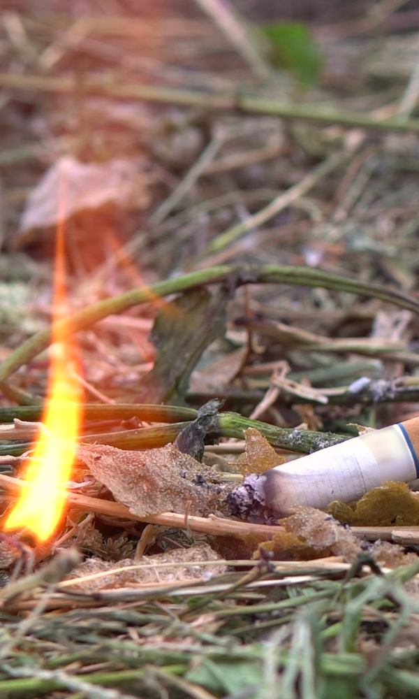 Zigarette, die ein Flamme auf trockenem Boden erzeugt