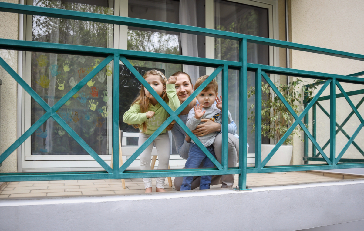 Frau gemeinsam mit Kindern auf einem Balkon