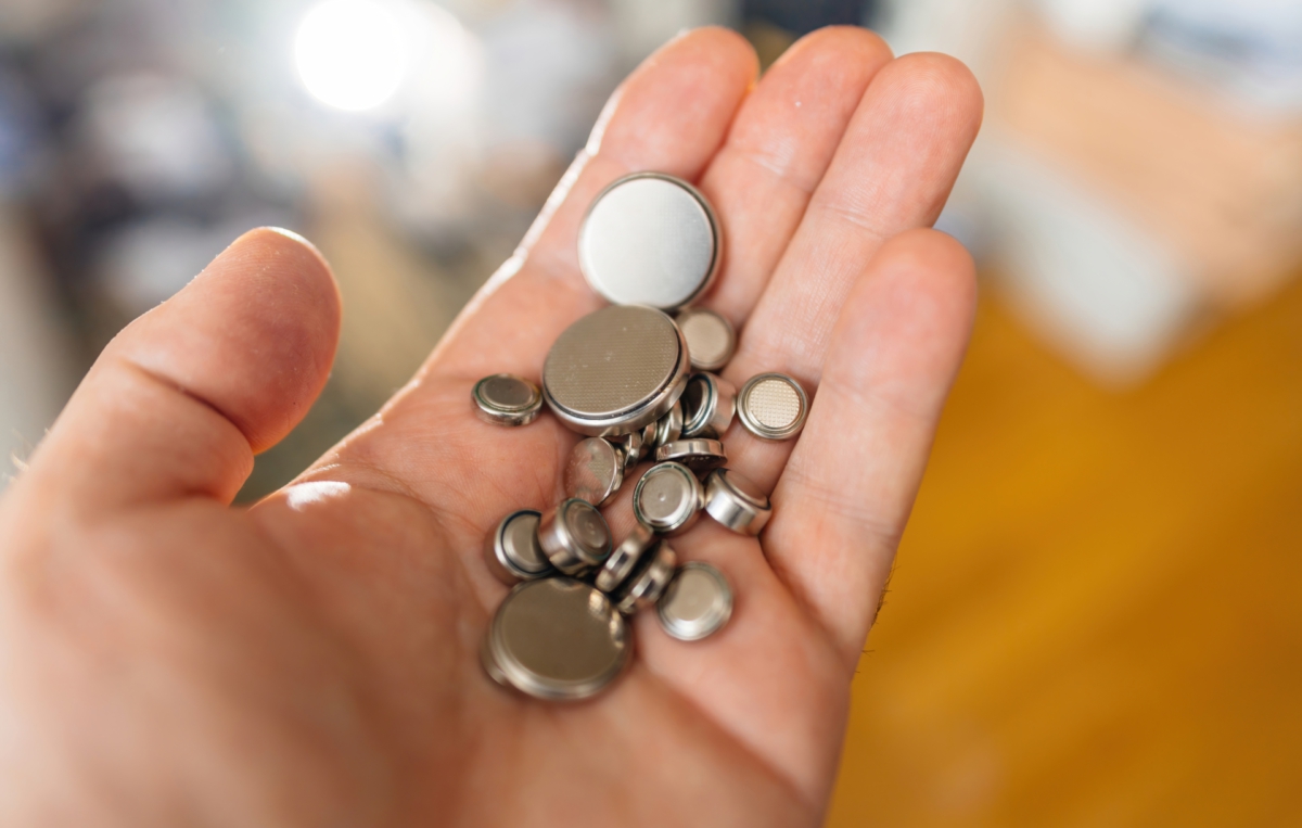 Handfläche mit vielen kleinen runden Batterien